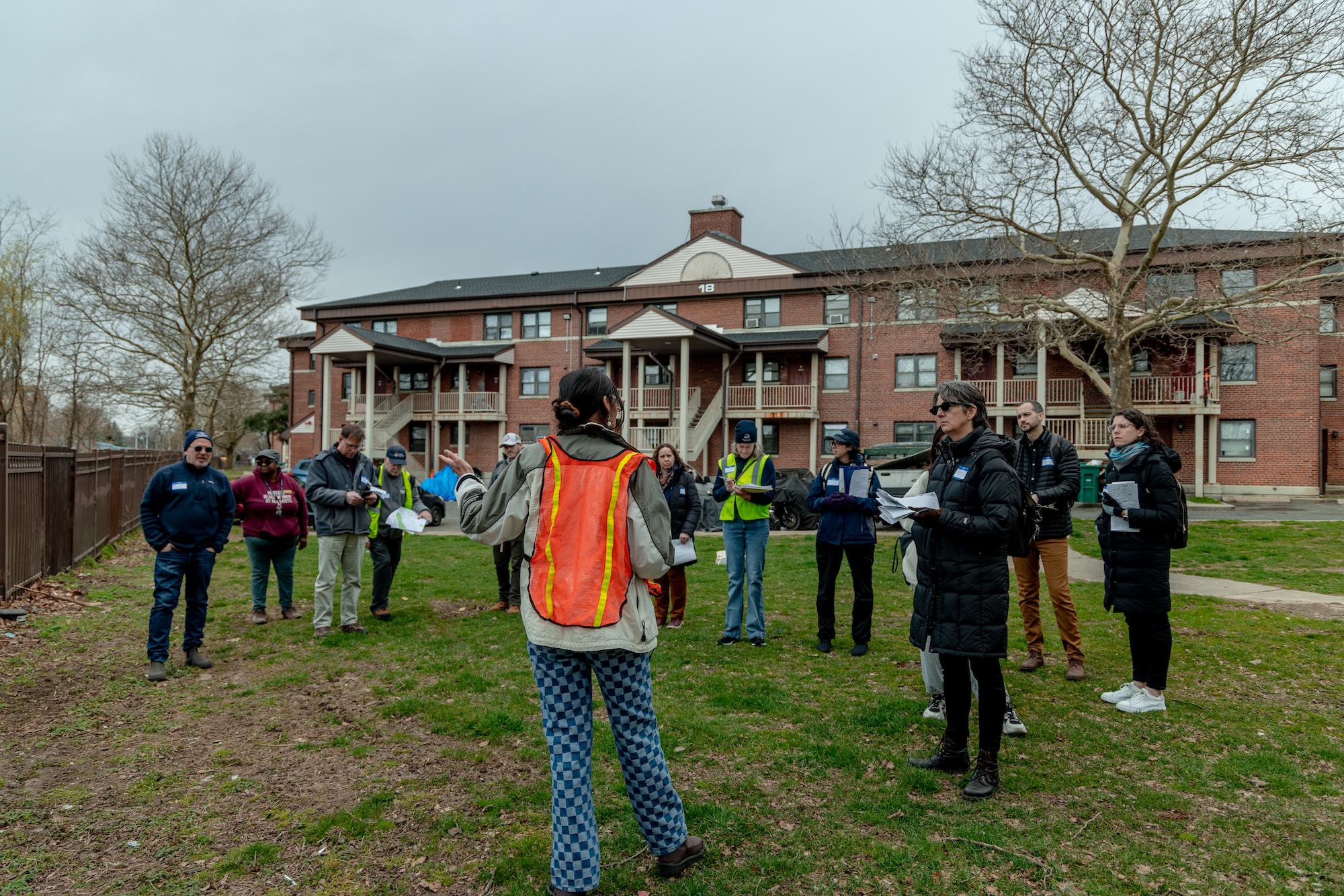 Group of people stand outside a building getting a site tour