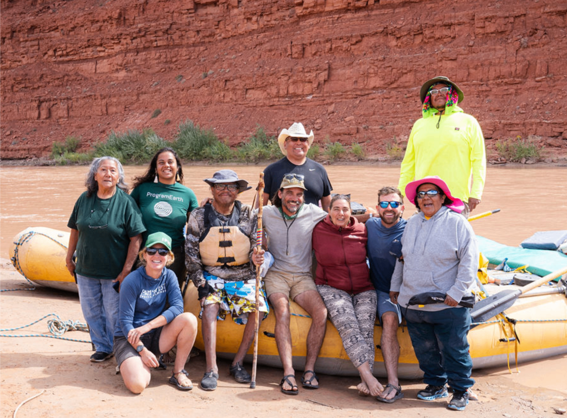 Group of people in front of an inflatable raft near a river